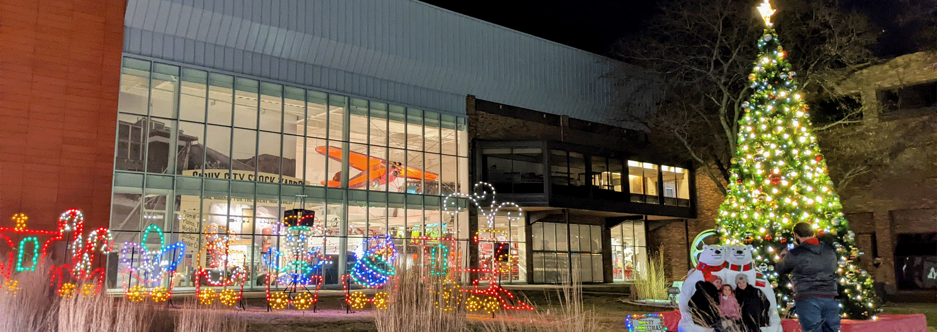 Museum Plaza with lighted Christmas tree and people taking a photo